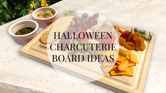 Halloween charcuterie board on a maple cutting board with cheese, grapes and crackers